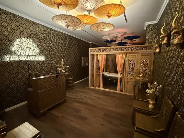 Empfang mit der handbemalten Theke und dem leuchtenden Lotus-Logo, dahinter die Teak-Kabine unter der Schirmdecke