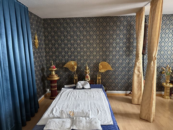 Studio Schützengraben 23: Massageraum mit goldenen Fächern und Tempelfigur