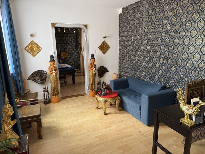 Studio Schützengraben 23: Wartebereich mit Sofa und Thai-Tapete